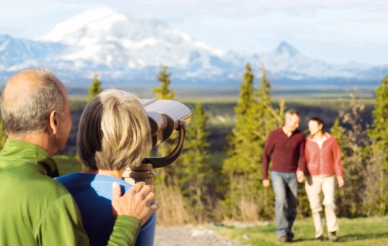 Couple looking through binoculars at Mt. Blackburn