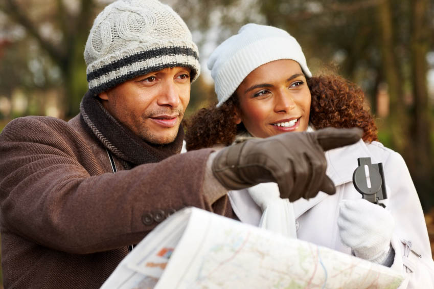 Smiling couple with map looking for directions